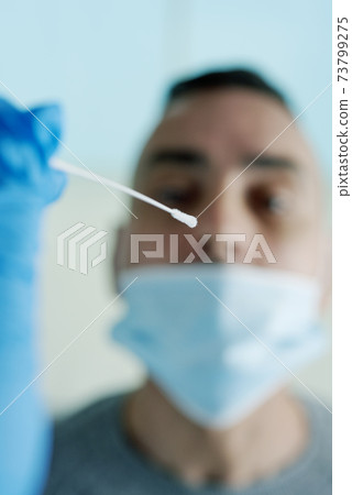 about to take a nasopharyngeal sample to a patient about to take a nasopharyngeal sample to a patient 73799275