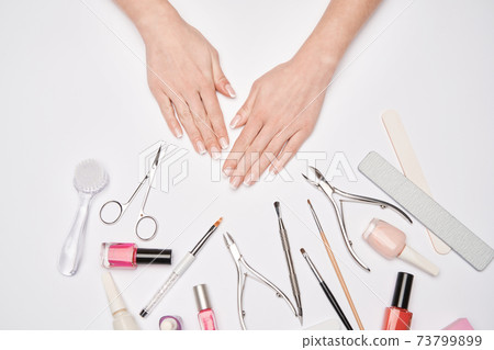 top view of manicure tools set for nail care over light background - brush, scissors, nail polish, file and tweezers top view of manicure tools set for nail care over light background - brush, scissors, nail polish, file and tweezers 73799899