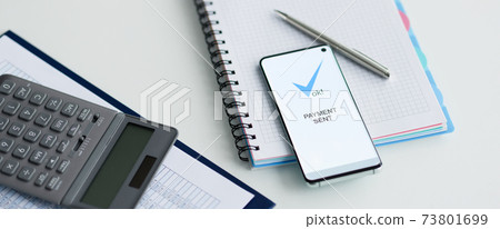 On table lies a smartphone with inscription payment sent documents and calculator On table lies a smartphone with inscription payment sent documents and calculator 73801699