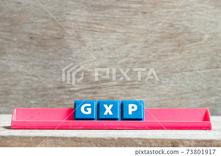 Tile letter on red rack in word GXP on wood background 73801917