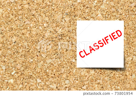 White note paper with word classified on corkboard background 73801954