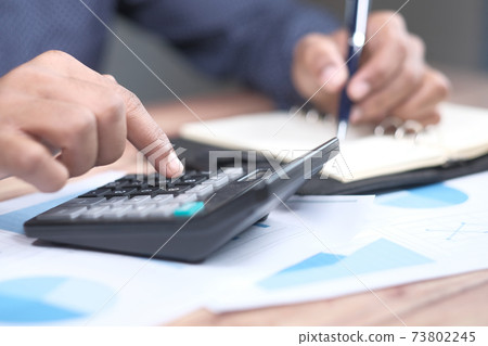 close up of accountant using calculator on office desk. close up of accountant using calculator on office desk. 73802245