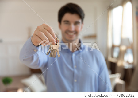 Close up happy man showing keys to new apartment Close up happy man showing keys to new apartment 73802332