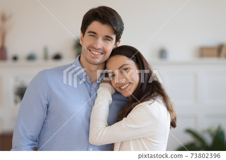 Head shot portrait smiling man and woman hugging, standing 73802396