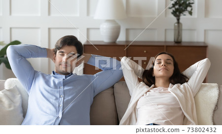 Close up young woman and man resting on couch together 73802432
