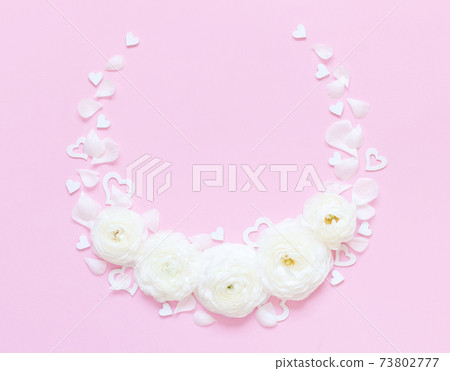 Circle frame made of cream flowers and hearts on a light pink background Circle frame made of cream flowers and hearts on a light pink background 73802777