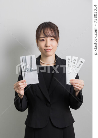 一名身著哀悼服的年輕女子站在一個非祝賀的袋子裡[葬禮] 73803014