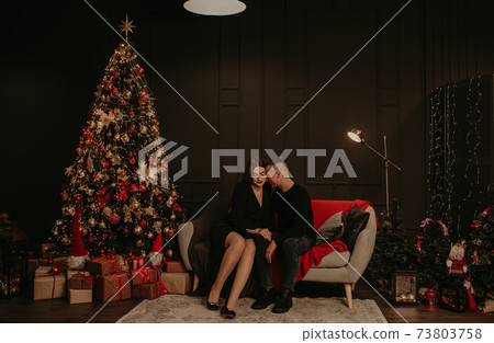 love couple man and woman hugging kissing near Christmas tree. love couple man and woman hugging kissing near Christmas tree. 73803758