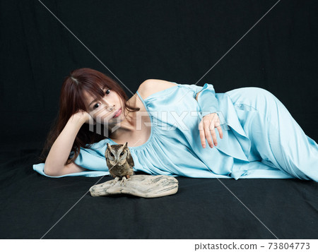 躺下與貓頭鷹和決定姿勢的一個少婦 73804773