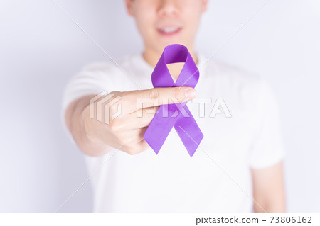 World cancer day, hands holding purple ribbon on grey background with copy space for text. Healthcare and medical concept. World cancer day, hands holding purple ribbon on grey background with copy space for text. Healthcare and medical concept. 73806162