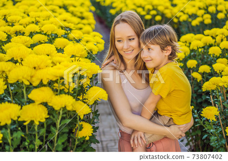Caucasian tourists mother and son in Tet holidays. Vietnam Chinese Lunar New Year in springtime Caucasian tourists mother and son in Tet holidays. Vietnam Chinese Lunar New Year in springtime 73807402