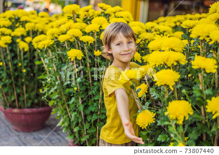 Caucasian tourist boy in Tet holidays. Vietnam Chinese Lunar New Year in springtime Caucasian tourist boy in Tet holidays. Vietnam Chinese Lunar New Year in springtime 73807440