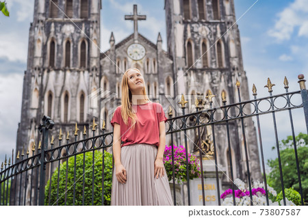 Young woman tourist on background of St Joseph's Cathedral in Hanoi. Vietnam reopens after coronavirus quarantine COVID 19 Young woman tourist on background of St Joseph's Cathedral in Hanoi. Vietnam reopens after coronavirus quarantine COVID 19 73807587