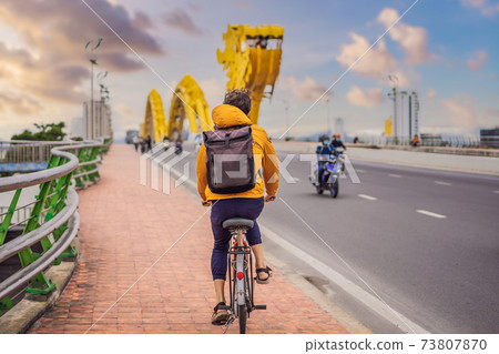 A man rides a bicycle on the dragon bridge in Da Nang 73807870