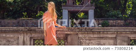 BANNER, LONG FORMAT Woman tourist in Temple of Literature in Hanoi in Southeast Asia, Vietnam. Temple of Confucius in Vietnamese capital. Vietnam reopens after coronavirus quarantine COVID 19 73808214