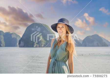 Attractive woman in a dress is traveling in Halong Bay. Vietnam. Travel to Asia, happiness emotion, summer holiday concept. Picturesque sea landscape. Ha Long Bay, Vietnam Attractive woman in a dress is traveling in Halong Bay. Vietnam. Travel to Asia, happiness emotion, summer holiday concept. Picturesque sea landscape. Ha Long Bay, Vietnam 73808273