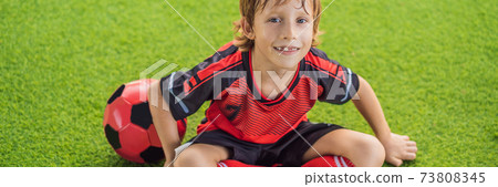 BANNER, LONG FORMAT Little cute kid boy in red football uniform playing soccer, football on field, outdoors. Active child making sports with kids or father, Smiling happy boy having fun in summer 73808345