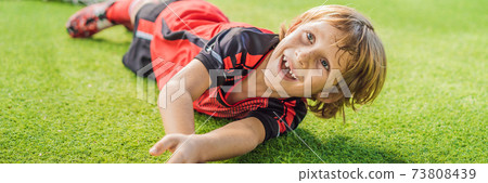 BANNER, LONG FORMAT Little cute kid boy in red football uniform playing soccer, football on field, outdoors. Active child making sports with kids or father, Smiling happy boy having fun in summer 73808439