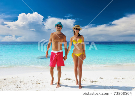 Couple walking on a tropical beach 73808564
