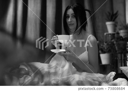 beautiful young woman drinking her coffee beautiful young woman drinking her coffee 73808684