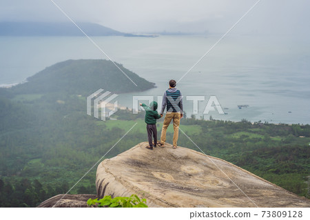 Dad and son are travelers in Hai Van Pass, Danang, Vietnam 73809128