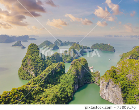 Aerial view panorama of floating fishing village and rock island, Halong Bay, Vietnam, Southeast Asia. UNESCO World Heritage Site. Junk boat cruise to Ha Long Bay. Popular landmark of Vietnam Aerial view panorama of floating fishing village and rock island, Halong Bay, Vietnam, Southeast Asia. UNESCO World Heritage Site. Junk boat cruise to Ha Long Bay. Popular landmark of Vietnam 73809176