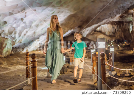 Mom and son tourists in Hang Sung Sot Grotto Cave of Surprises, Halong Bay, Vietnam. Traveling with children concept. Tourism after coronavirus 73809290