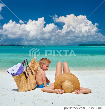 Woman with three year old boy on beach 73809308