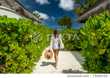 Woman with bag and sun hat going to beach 73809326