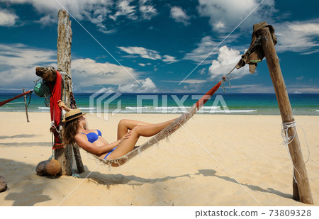 Woman in hammock on beach Woman in hammock on beach 73809328