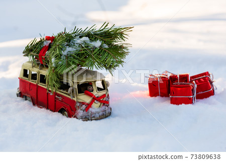 Red toy bus with a Christmas tree on the snow Red toy bus with a Christmas tree on the snow 73809638
