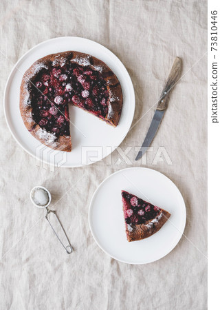 Vegan almond berry galette on white tablecloth background. 73810446