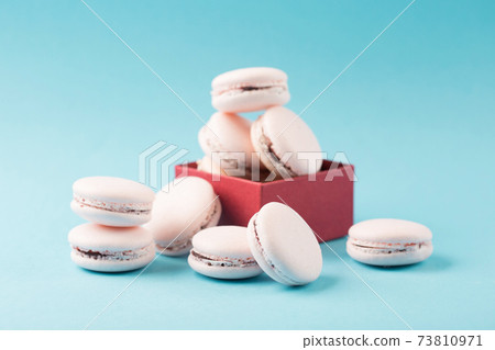 Pink french cookies macaroons on blue background, copy space. Pink french cookies macaroons on blue background, copy space. 73810971