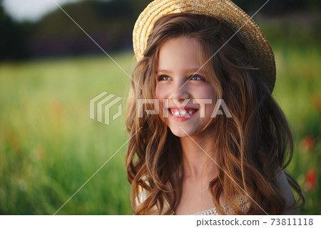 cute little girl in meadow with red poppies 73811118