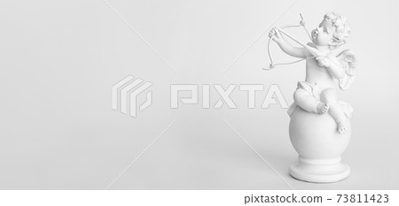 Banner. figurine of an angel Cupid with a bow on a pink background. Valentine's Day. Banner. figurine of an angel Cupid with a bow on a pink background. Valentine's Day. 73811423