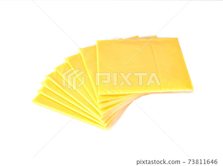 Slices of processed cheese on a white background. Square slices of cheese for a burger close-up. Slices of processed cheese on a white background. Square slices of cheese for a burger close-up. 73811646