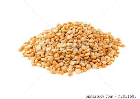 Pile of chopped peas on a white background. Yellow peas scattered by a hill on a white background. 73811693