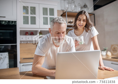 Couple checking morning emails while having coffee Couple checking morning emails while having coffee 73811838