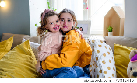 Sisters indoors at home, playing with lipstick. Lockdown concept. 73812410