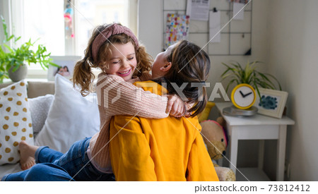 Sisters indoors at home, hugging. Lockdown concept. Sisters indoors at home, hugging. Lockdown concept. 73812412