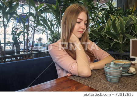 Side view of beautiful lady lond blond hair looking at sugar bowl on table. Copyspace Image Of lass Having Coffee Drink Side view of beautiful lady lond blond hair looking at sugar bowl on table. Copyspace Image Of lass Having Coffee Drink 73812633