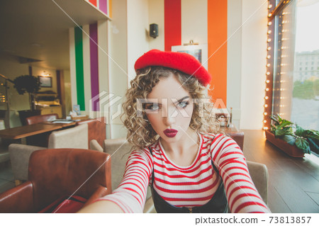 Pretty young woman taking selfie in cafe on blurred background 73813857