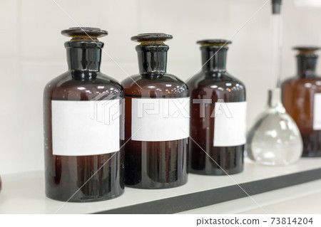 Brown bottles on a shelf in the laboratory. 73814204