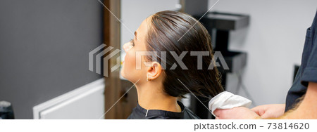 Hairdresser dries the washed hair 73814620