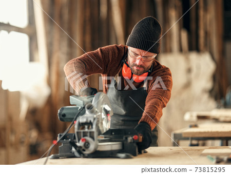 Joiner working with electric machine in workshop Joiner working with electric machine in workshop 73815295