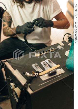 Tattoo artist workplace with machine and bottles with black tattoo ink Tattoo artist workplace with machine and bottles with black tattoo ink 73816187