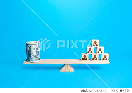 People blocks pyramid and rolled up bundle of dollars on scales. Financing the company and remuneration of staff. Organization accounting. Investments in human capital. Tax collection. Salary fund. People blocks pyramid and rolled up bundle of dollars on scales. Financing the company and remuneration of staff. Organization accounting. Investments in human capital. Tax collection. Salary fund. 73816710