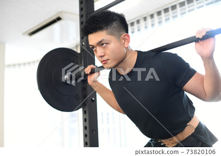 A man squatting in the gym A man squatting in the gym 73820106