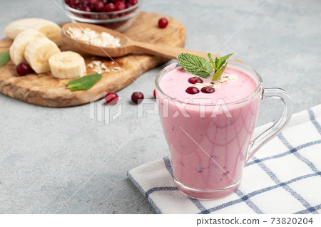 Homemade yogurt smoothie with banana, cranberry and oatmeal, copy space 73820204