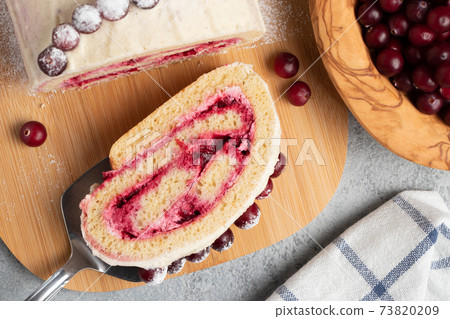 Homemade biscuit sweet roll with cranberries and cream on gray table, top view, flat lay Homemade biscuit sweet roll with cranberries and cream on gray table, top view, flat lay 73820209